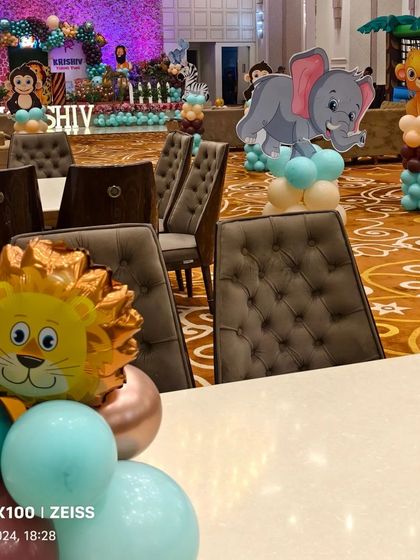 I use themed centerpieces and props throughout the venue. Here you can see the table decor and character cutouts that match the main jungle theme.