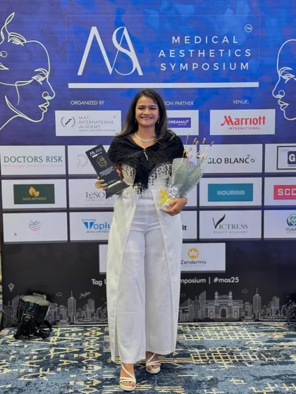 Holding my award and a bouquet of flowers, a lovely token of appreciation from the event organizers.