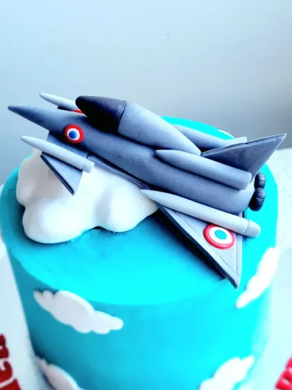 A close-up of the detailed gumpaste fighter jet topper, showing the emblems and shaping.