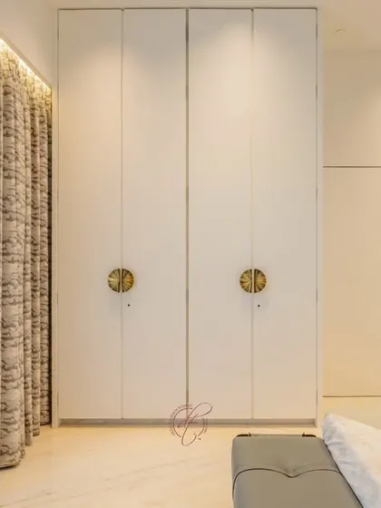 This view showcases the minimalist wardrobe with its unique circular gold handles. The design is a perfect blend of simplicity and sophisticated detailing.