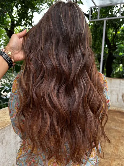 Getting her holiday-ready with a rich blend of copper and caramel highlights. This warm, wavy style is perfect for a festive getaway.