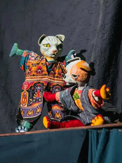 The cat and dog puppets finally make peace in a humorous scene from 'Hiss & Arf'. The show is a comedy that will tickle the imagination of young and old alike.