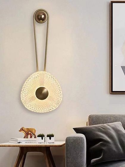 A unique wall sconce with a woven disc and a pulley-inspired design. This piece adds texture and a touch of industrial chic.