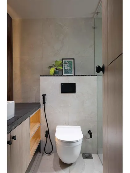 After: A clean and bright bathroom makeover. The combination of light wood, a simple white toilet, and a large mirror makes the space feel larger and more modern.
