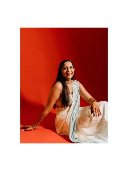 A vibrant and modern bridal portrait. The bride's joyful smile against the bold red background creates a stunning and memorable image.
