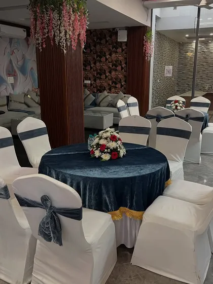 Another seating option with a dark blue velvet tablecloth and stylish grey velvet chair covers, perfect for a modern reception theme.