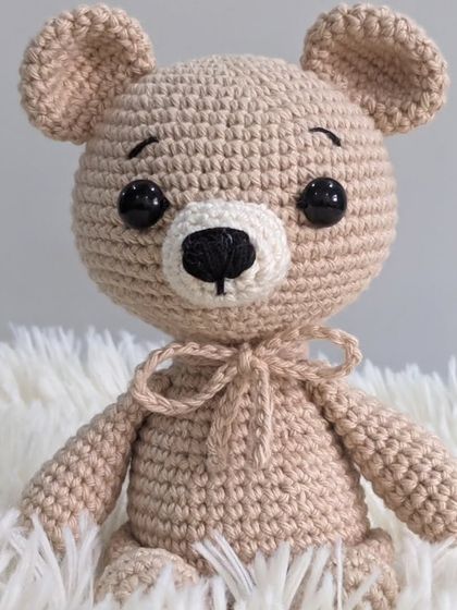 A classic beige teddy bear, this time with a sweet little bow tied around his neck.