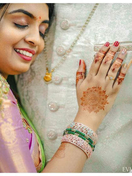 A close-up on the bride's hand, showcasing her beautiful henna and engagement ring as she rests her hand on the groom.