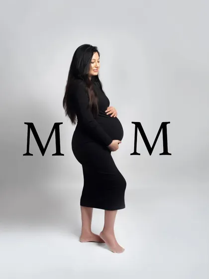 A simple and powerful solo portrait celebrating the mom-to-be. The clean background and classic black dress put all the focus on her and her beautiful baby bump.