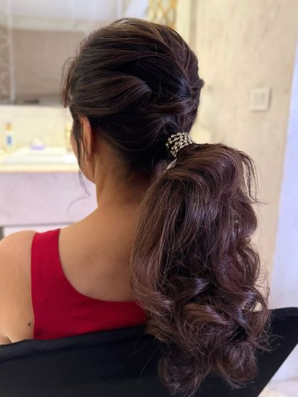 A textured, twisted low ponytail with a crystal accessory, a romantic and stylish option.