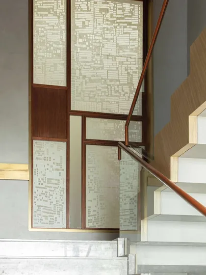 The main staircase at the Bammi Residence, featuring intricate Sanjhi screens by artist Vijay Kumar Verma at the landing. This detail showcases our approach of integrating traditional Indian crafts into functional architectural elements.