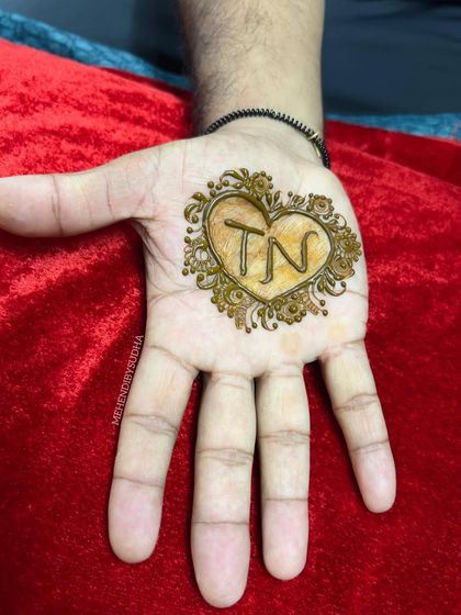 Mehendi for the groom! A simple yet meaningful design featuring the couple's initials inside a heart, a lovely way for the groom to honor his bride.
