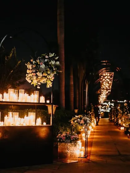 A walkway illuminated by hundreds of candles. We lined the path with candles of varying heights to create a magical, glowing journey for guests as they moved through the event space.