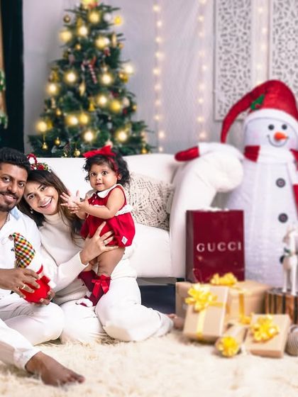 A happy family wrapped up in each other is the best Christmas gift. This wide shot shows the full festive scene, complete with presents and a cheerful snowman.
