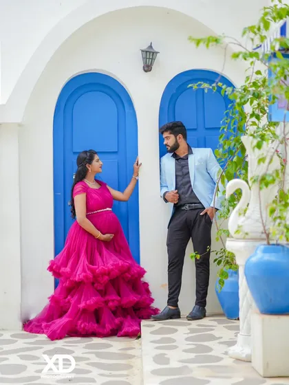 A romantic gaze between the couple, set against the popular Santorini-style blue doors. The vibrant pink gown adds a beautiful pop of color.