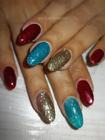 A bold and festive set for the new year, with a mix of red, blue, and gold glitter nails.