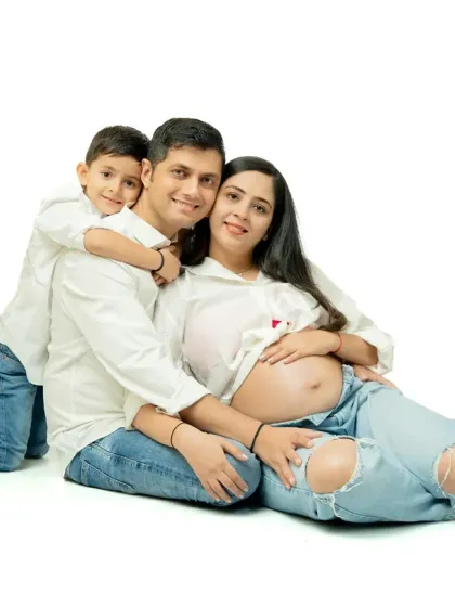 Family maternity sessions are full of joy and real moments. This shot captures the excitement of a big brother-to-be, celebrating the growing family in a relaxed, fun studio setting with casual matching outfits.