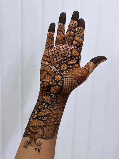 A gorgeous design on the back of the hand, featuring a floral vine that trails up the arm. The use of dark and light shading gives the flowers a three-dimensional feel.
