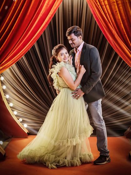A sweet and romantic indoor pre-wedding photo. The light green ruffled gown is a soft and pretty choice for a stage-like setting.