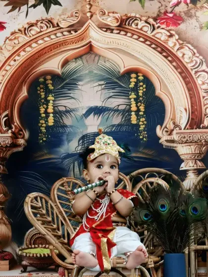 This little Krishna is captured playing his flute, fully immersed in his divine character within our beautiful studio set.