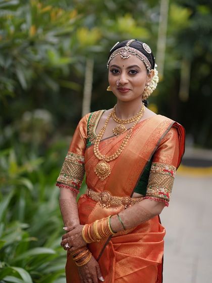 A close-up of the bride, showing her traditional headpiece and the detailed embroidery on her blouse.