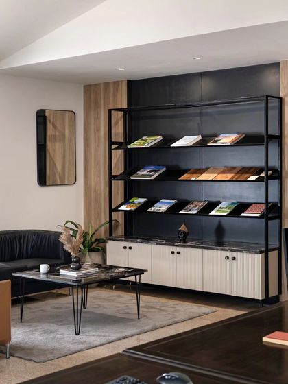 I custom-built this display rack for my studio to showcase materials to clients. It combines sleek matte black metal sections with beige fluted cabinets and a black marble countertop. It's a functional piece that is also a statement on material and craftsmanship.