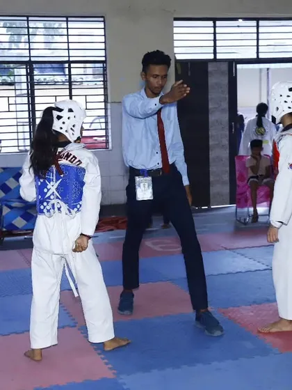 A referee gives instructions before a match. We ensure our students understand the rules and etiquette of competitive sparring.