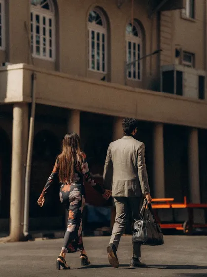 A shot from behind as they walk away, hand in hand. It creates a sense of journey and narrative, as if we are watching their story unfold on the streets of Mumbai.