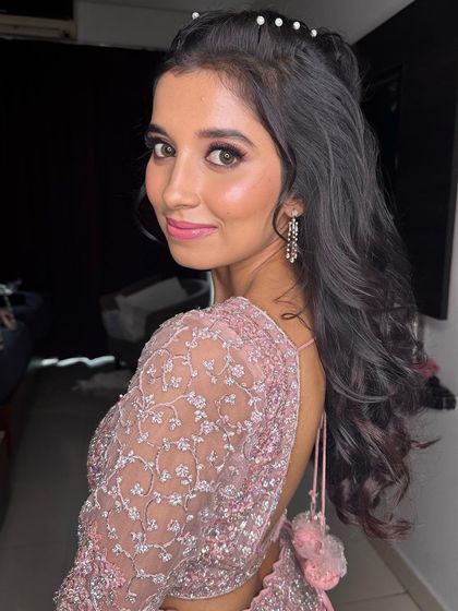 A side profile showing the cute, pearl-adorned hairstyle and the soft, glowing makeup from another angle.