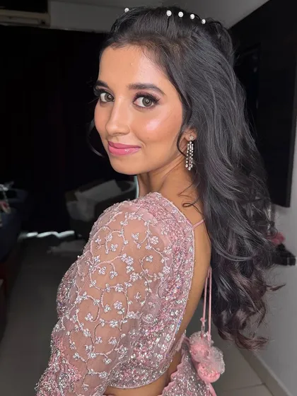 A side profile showing the cute, pearl-adorned hairstyle and the soft, glowing makeup from another angle.