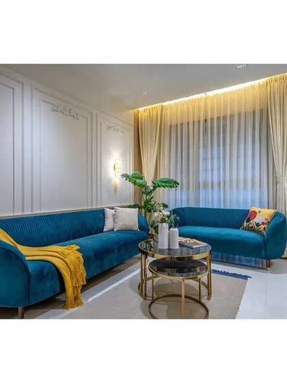 The fluted texture of the teal sofa adds a layer of tactile detail. We believe that luxury is found in both the visual appeal and the feel of the materials we choose.