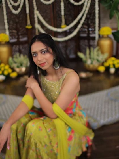 The bride posing in her vibrant mehendi outfit against the traditional decor. I work to ensure the decor complements the couple's style and attire perfectly.