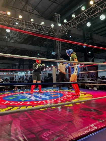 A wide view of the boxing ring during a championship. Competing on this stage is a testament to the rigorous training and fighting spirit we build in the gym.