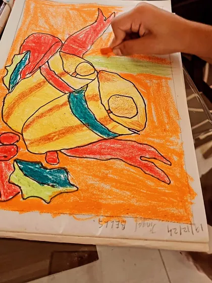 Here, a student is using oil pastels to create a vibrant, abstract composition. This shows our hands-on approach to teaching color blending and texture with different materials.