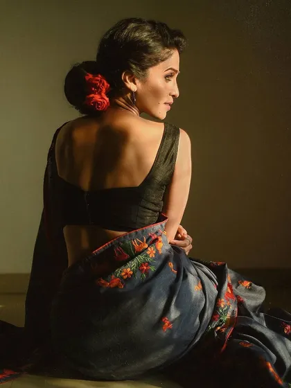 This shot focuses on the elegance of the pose and the details of the saree. The composition, showing the model from the back, highlights the beautiful drape of the fabric and the graceful curve of her posture.