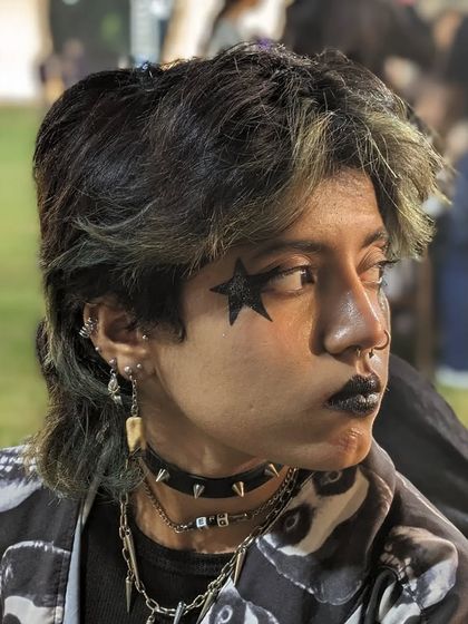 A cool, gothic-style look with a black star over the eye and black lipstick, perfect for a themed party.