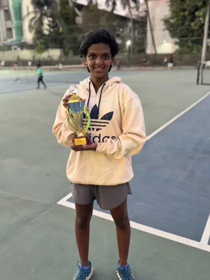 Mohak Kulkarni holding his runner-up trophy on the court.