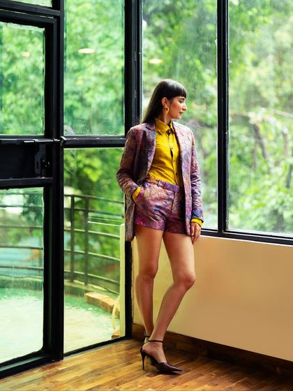 A brocade shorts suit paired with a bright yellow shirt. This is a great example of how traditional Indian fabrics can be used in modern, western silhouettes.