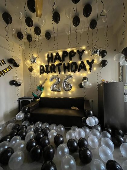 A 26th birthday room decoration in black and silver, with balloons covering the floor and ceiling.