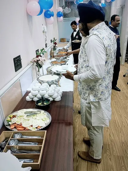 Guests enjoying a lavish spread served by my team. My staff is trained to manage the buffet efficiently, ensuring a smooth flow even at large gatherings.