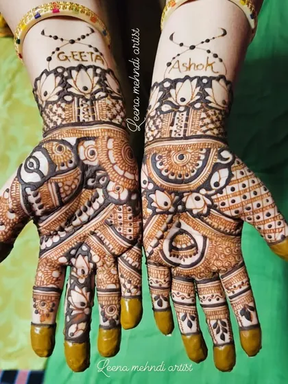 Personalizing mehndi with the couple's names, 'Geeta' and 'Ashok'. This is a wonderful way to add a personal touch to the traditional designs for your special day.