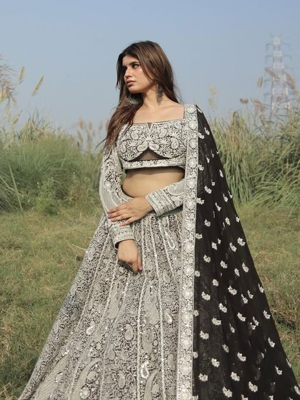 A breathtaking black and white embroidered lehenga that is both classic and modern. The intricate threadwork creates a stunning contrast, perfect for a formal reception.