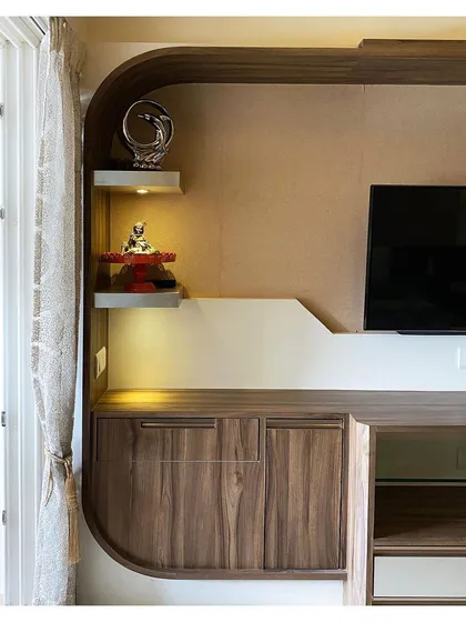 A detail of the TV unit, showing the soft, rounded edges and backlit shelves for displaying decorative items, adding a touch of elegance.