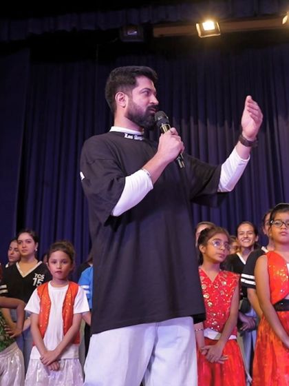 Speaking to a group of young students on stage. It feels amazing to share my passion and encourage the next generation of dancers.