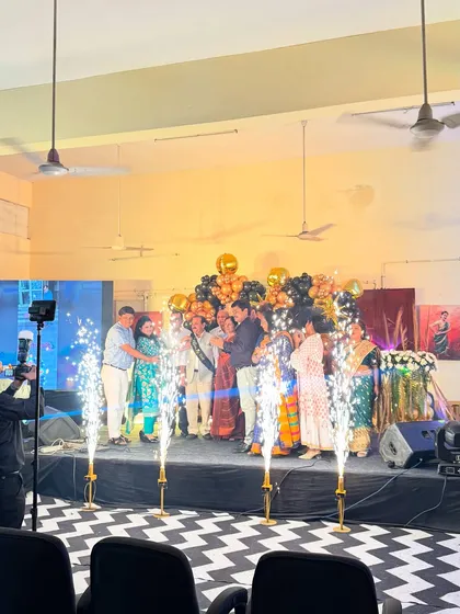 We handle decorations for large-scale events like this retirement party. The stage setup includes a balloon backdrop and multiple cold pyro sparklers that go off to highlight the main event, creating a memorable moment for everyone.