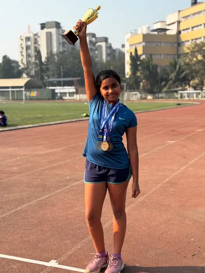 Zanna Fernandes celebrating her Best Athlete trophy win at her school sports day. Holding the trophy high, she is a symbol of victory and hard work.