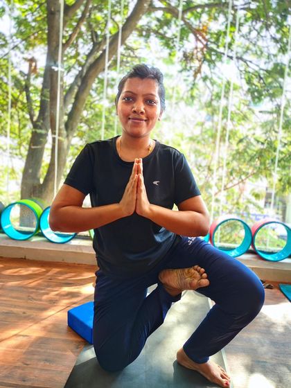 A happy and confident expecting mother in a modified balancing pose, showing how yoga can empower you throughout your pregnancy.