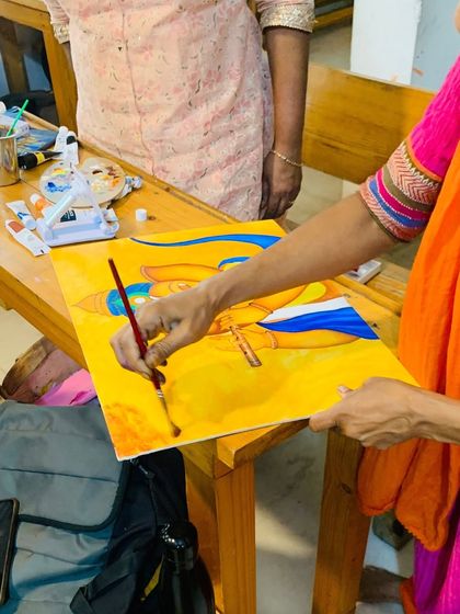 An instructor adds the finishing touches to a traditional painting of Lord Krishna. Acrylics are a versatile medium suitable for a wide range of styles, from modern to devotional.