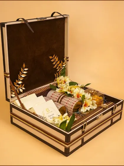 An open view of our signature wedding trousseau trunk, elegantly filled with gourmet jars, gift packets, and delicate floral arrangements. This is a perfect, luxurious gift for a bride-to-be.