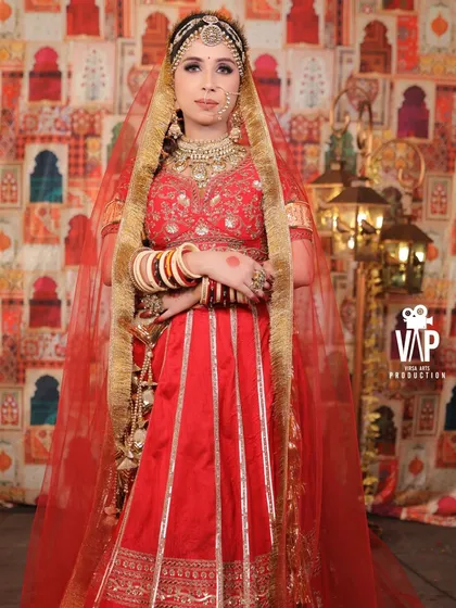 A full-length view with the dupatta draped over the head, showing the complete traditional bridal look. The gold border on the net dupatta ties the whole outfit together.